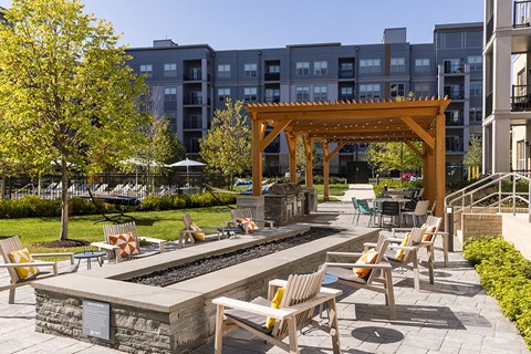an outdoor lounge area with tables and chairs in front of a building