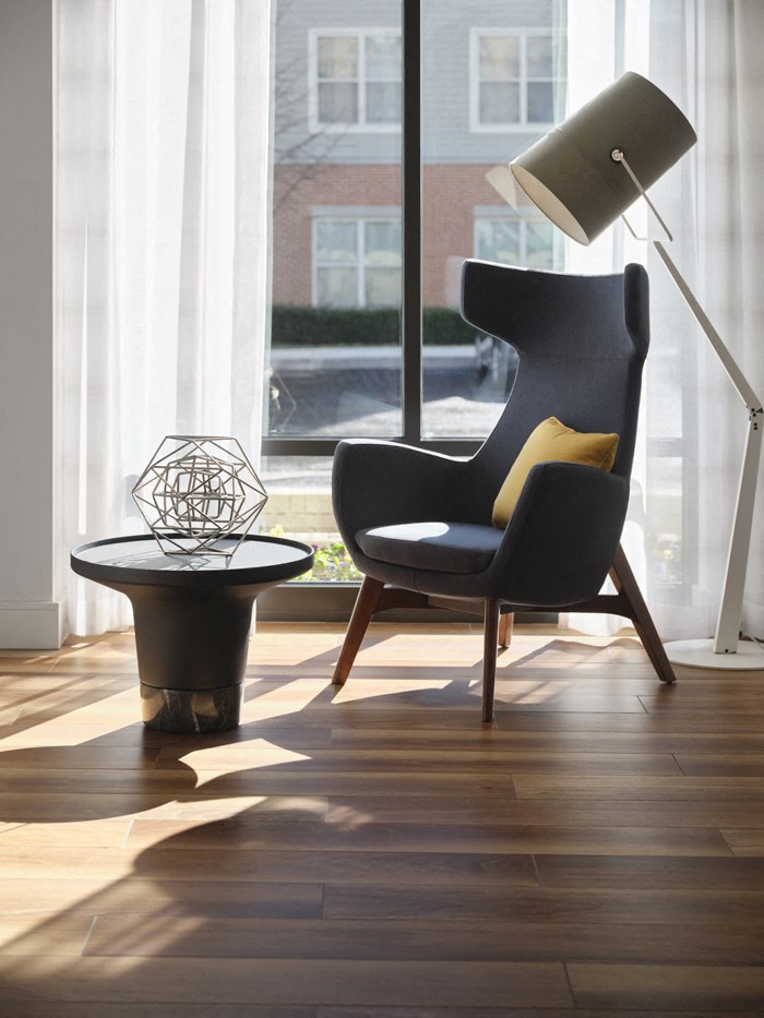 a chair with a lamp and a table in front of a window