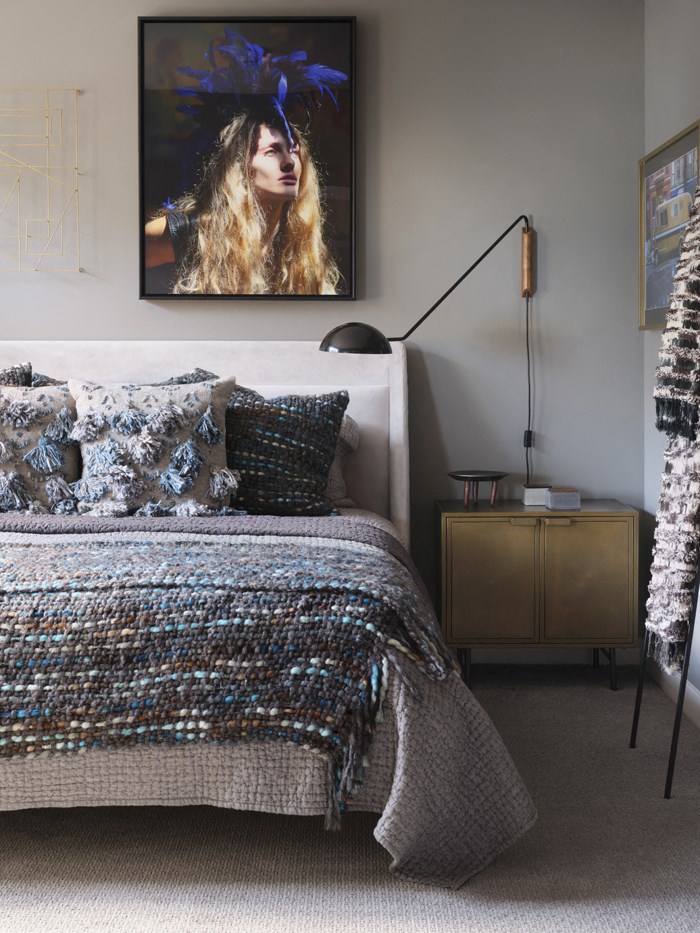 a bedroom with a bed and a painting on the wall