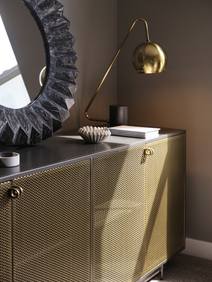 a gold cabinet with a mirror and a lamp on top