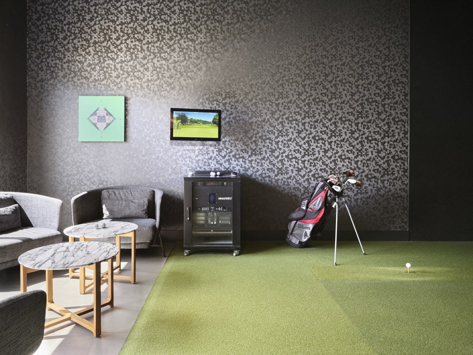 a room with a golf swing and a bag on a tripod