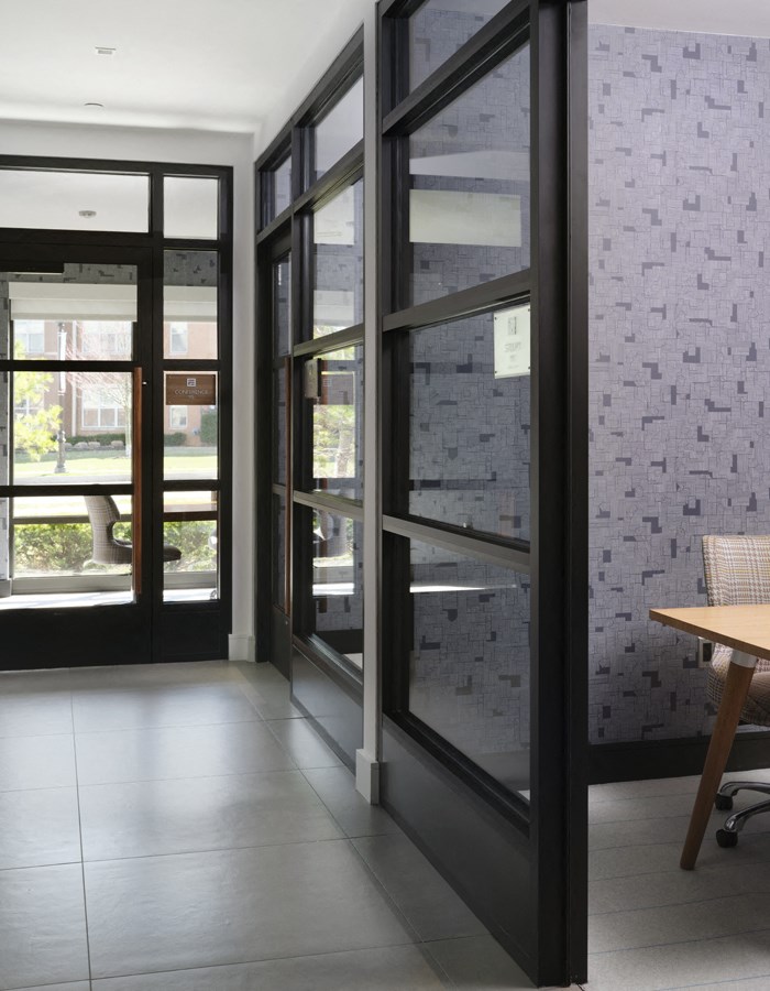 a view of a hallway with glass doors and a table
