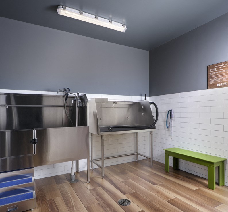 a large stainless steel sink in a room with a wooden floor