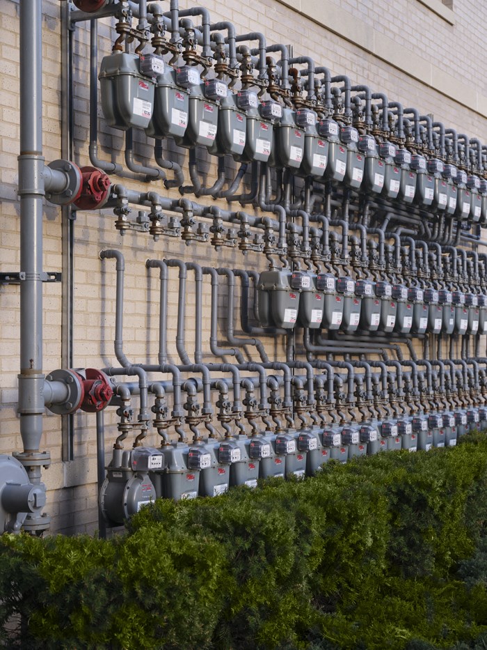 a wall of gas meters on the side of a building