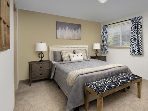A bedroom with a bed, nightstand, and window.