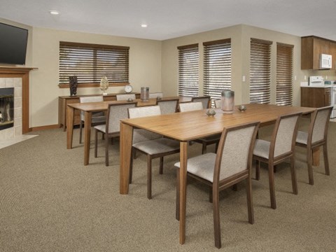 A dining room with a long table and chairs.