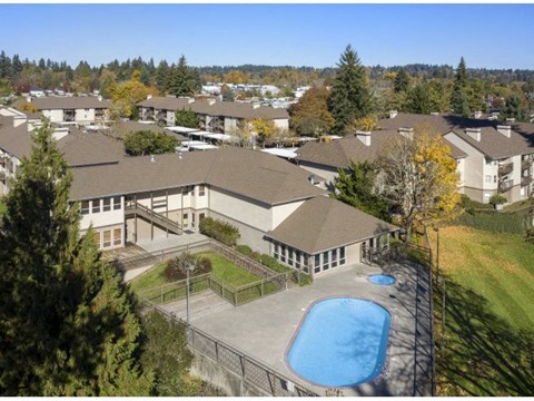 A large building with a pool in front of it.