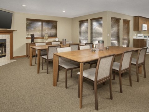A dining room with a wooden table and chairs.
