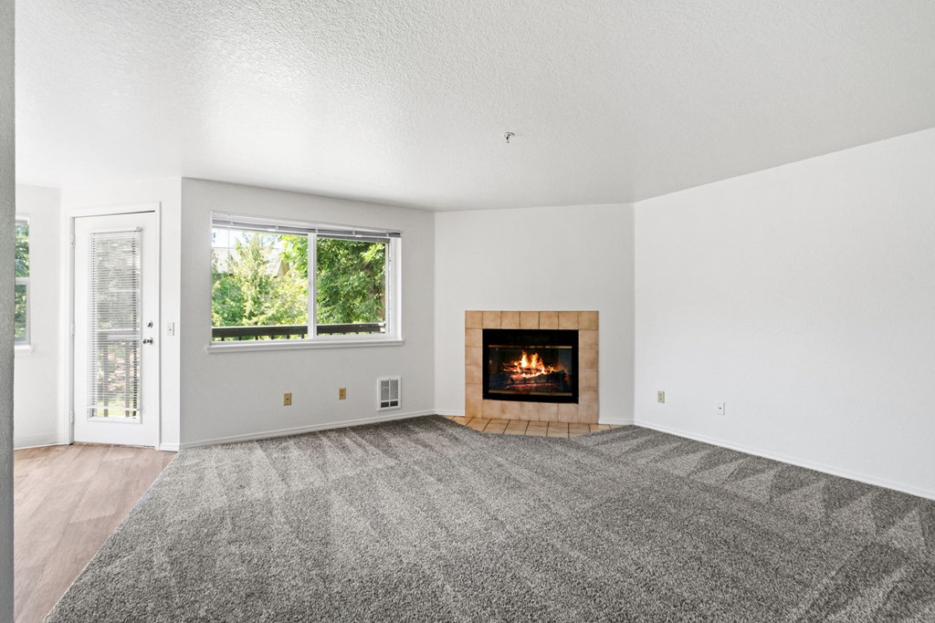 an empty living room with a fireplace and a window