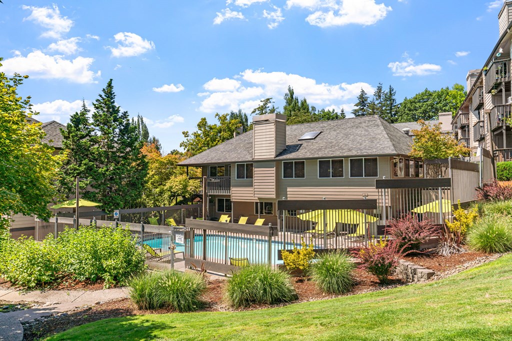 a backyard with a pool and a house with a fence
