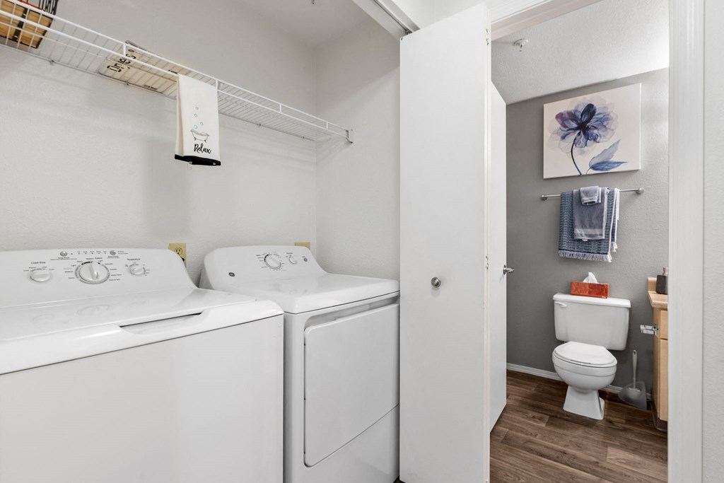 a washer and dryer in a laundry room next to a toilet