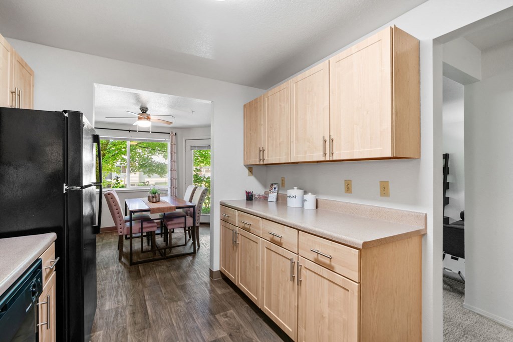 an open kitchen with wooden cabinets and a dining room with a table