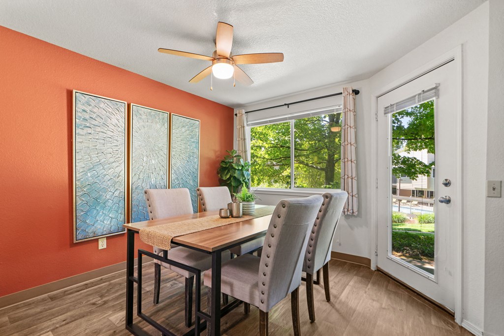 a dining room with a table and chairs and a ceiling fan