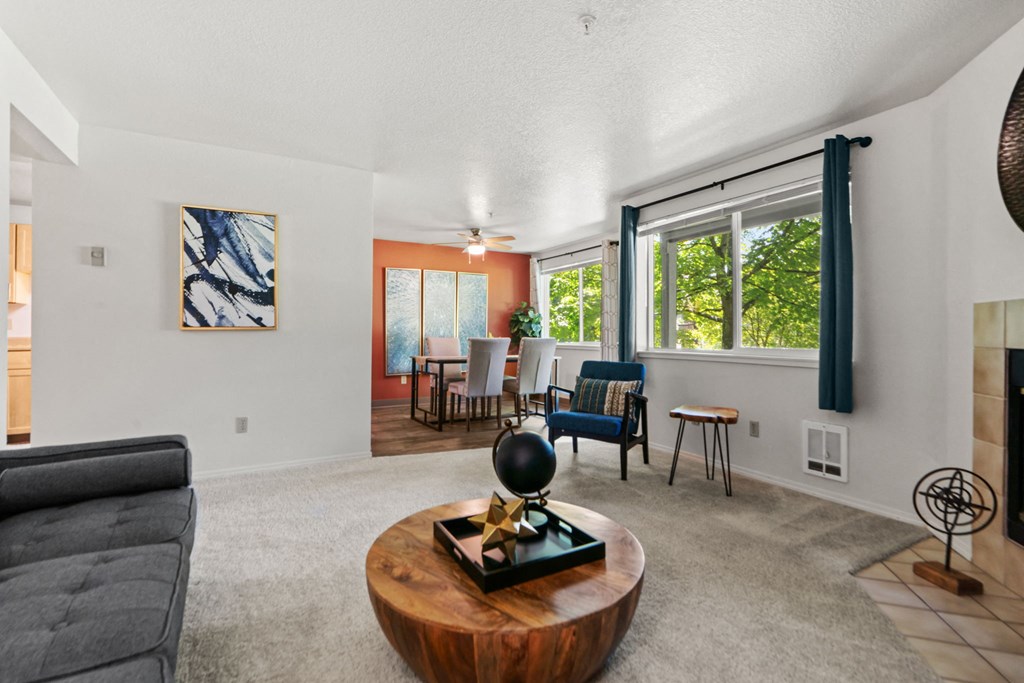 the living room and dining room of a house with a large window and a couch