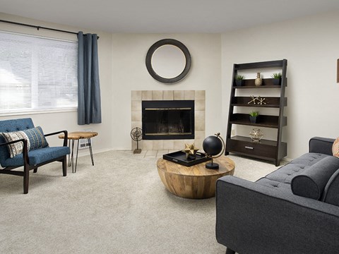 a living room with a fireplace and a round coffee table