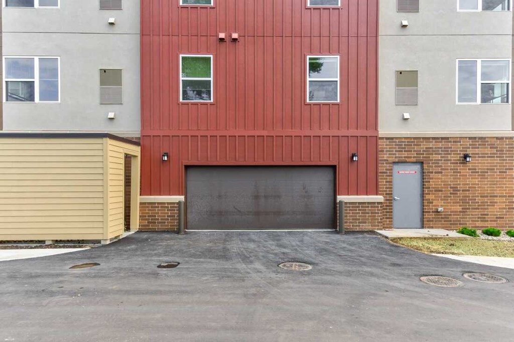 a garage door in front of a red building