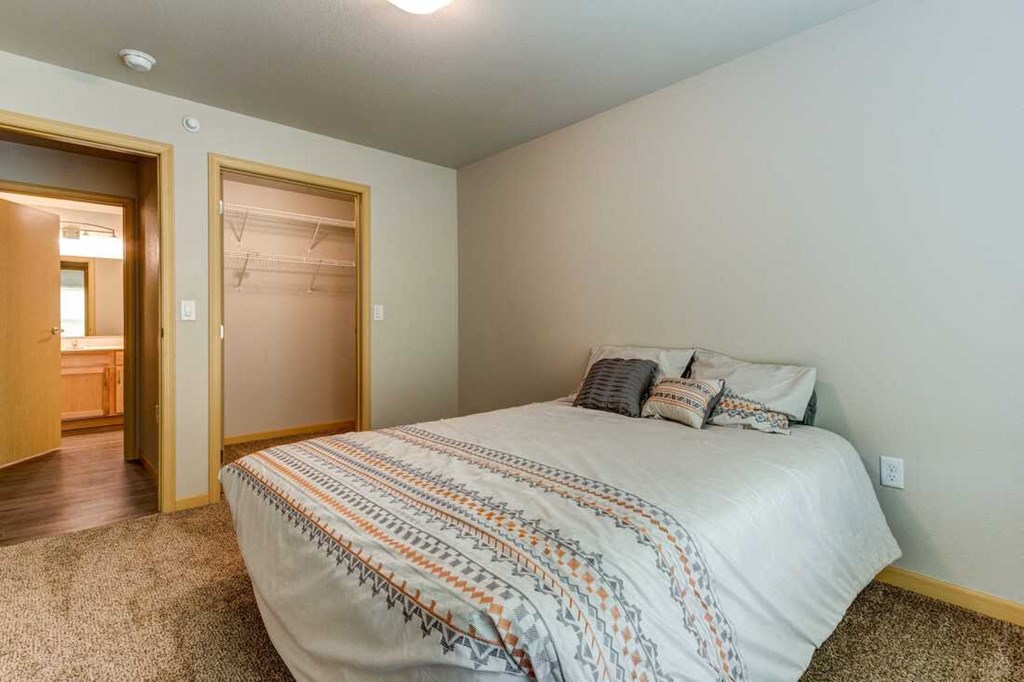 a bedroom with a bed and a door to a bathroom