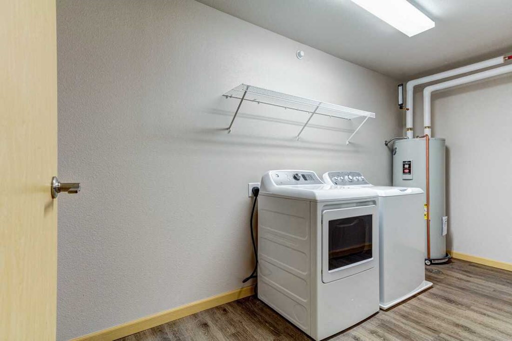 an empty laundry room with a washer and dryer on the wall