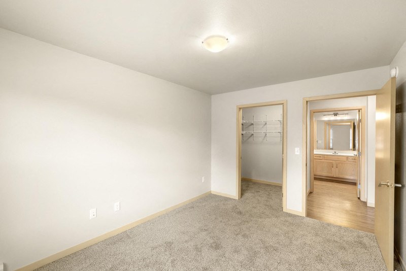 a living room with carpet and a door to a bathroom