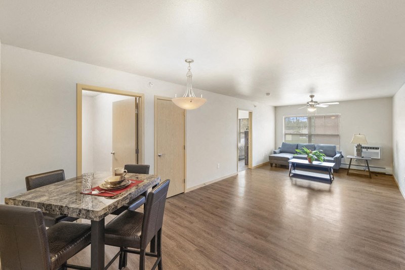 a living room and dining room with a table and chairs
