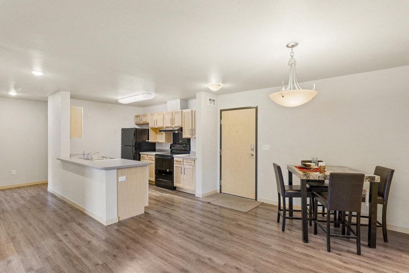 a dining room and kitchen with a table and chairs