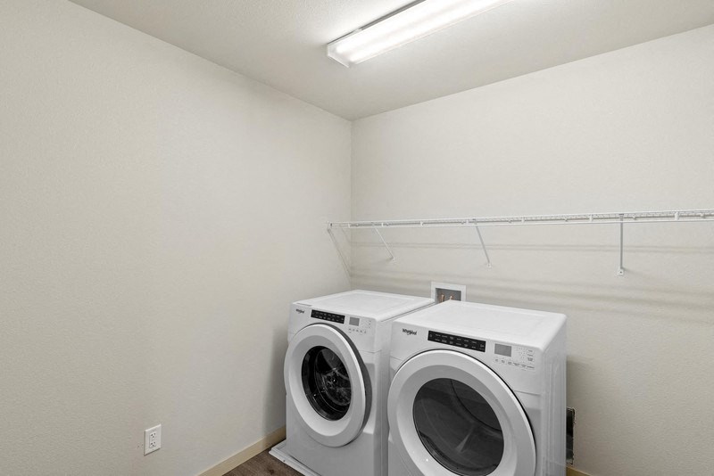 a washer and dryer in a laundry room with a white wall