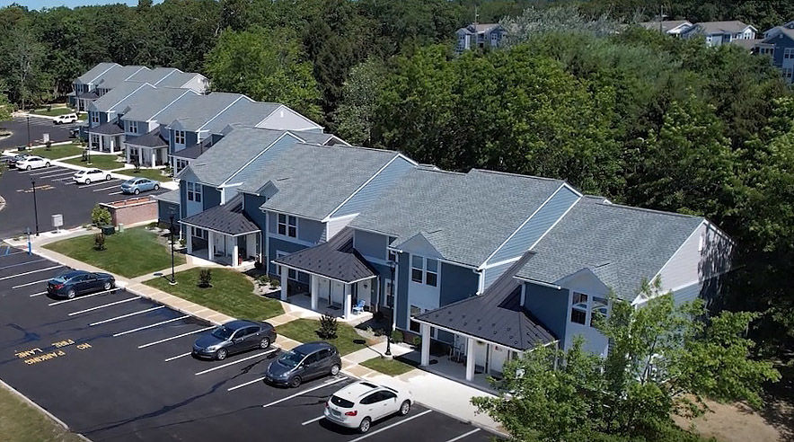 an aerial view of a row of houses with cars parked in a parking lot