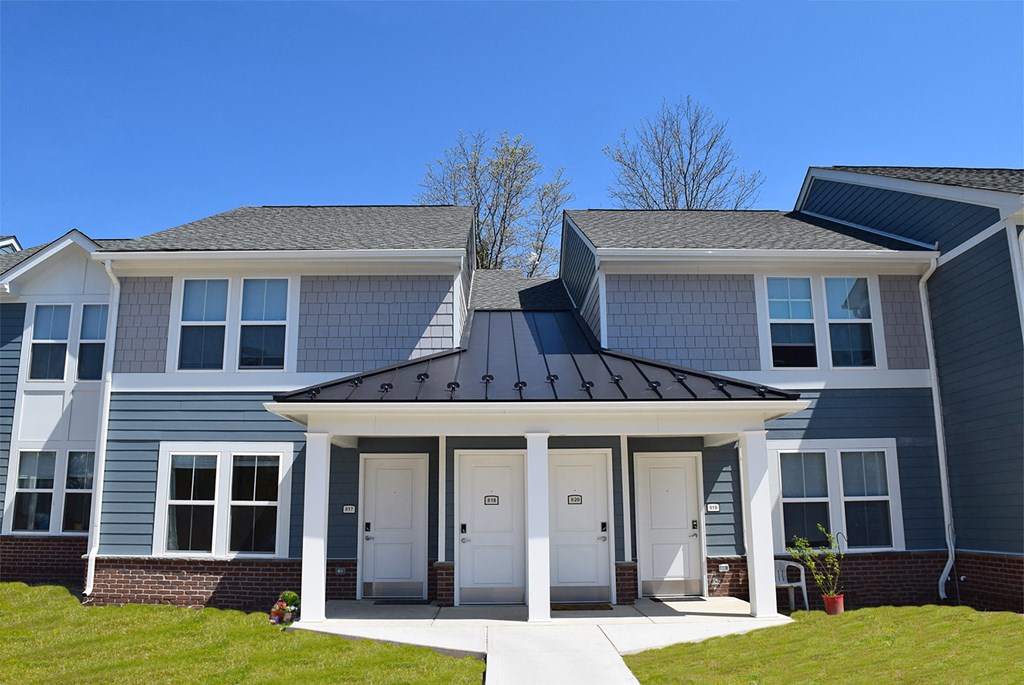 a blue house with a black roof on a sunny day