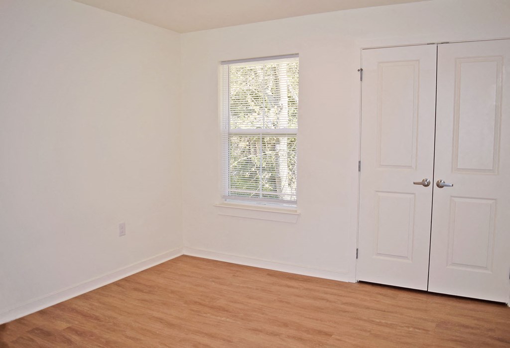 an empty room with white walls and a window and a door