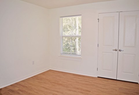 an empty room with white walls and a window and a door