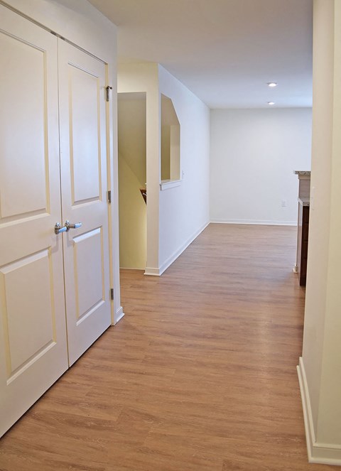 a hallway with white doors and a wooden floor