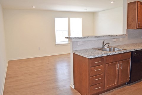 an empty kitchen with wood flooring and a sink