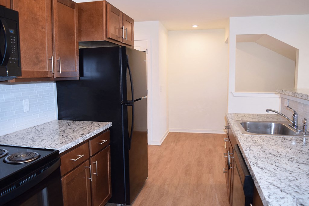 a kitchen with black appliances and granite counter tops