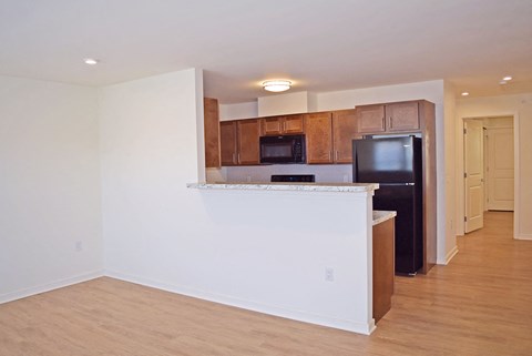 a kitchen with a counter and a black refrigerator