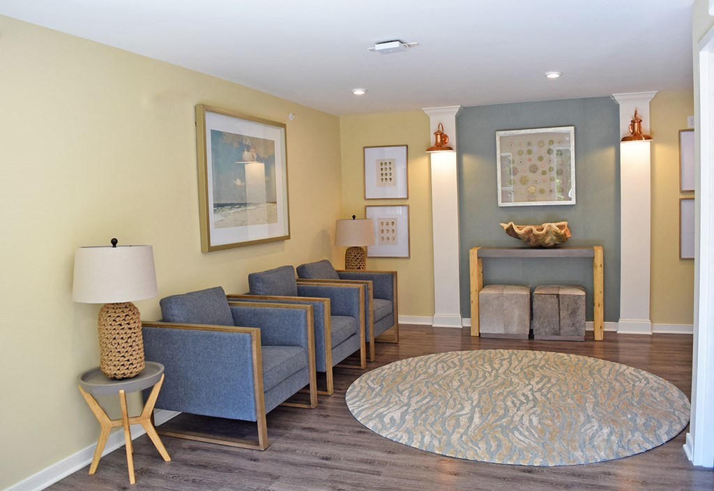 a living room with blue chairs and a rug