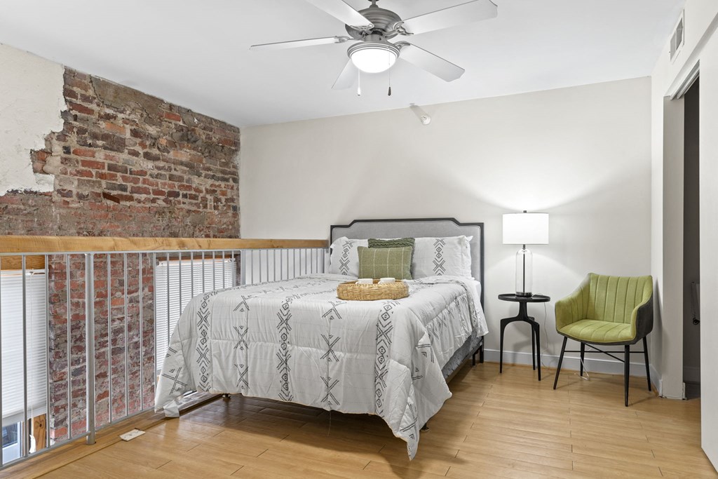 a bedroom with a bed and a brick wall