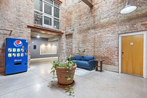 the lobby of a building with a blue couch and a potted plant