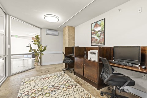 a home office with a desk and a television