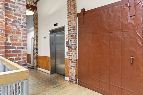 a large metal door in a room with a wooden floor