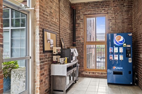a break room with a vending machine and a brick building