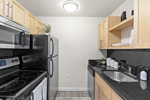 a kitchen with black appliances and wood cabinets