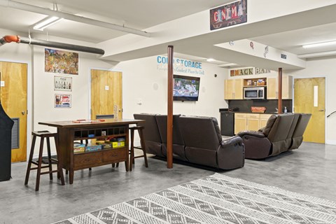 a living room with couches and a table and a kitchen