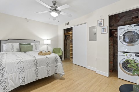 a bedroom with a bed and a washing machine and a washer and dryer