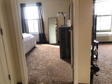 a bedroom with a bed and a dresser and a mirror
