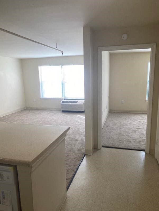 an empty kitchen and living room with a window