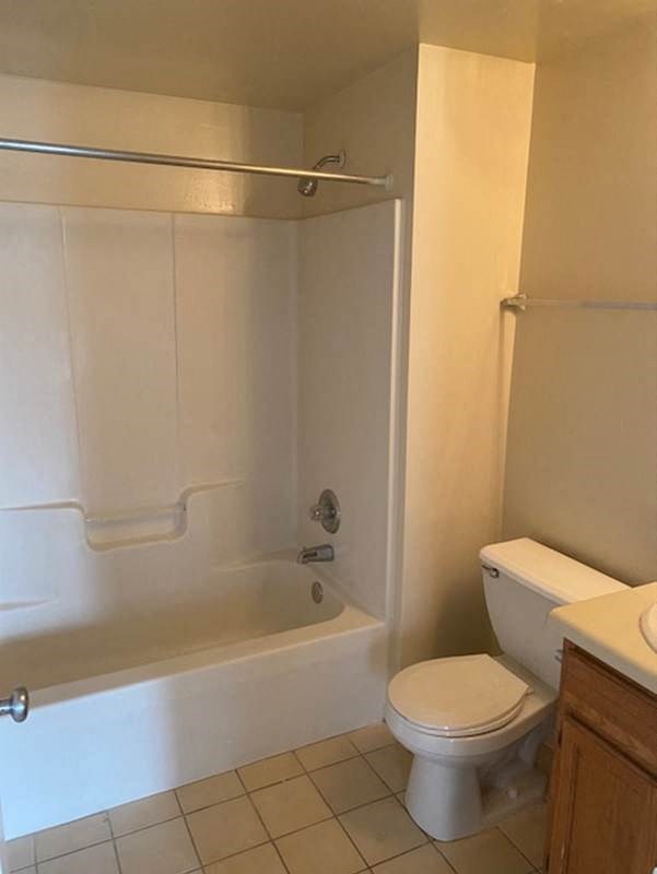 a white bathroom with a toilet and a bath tub