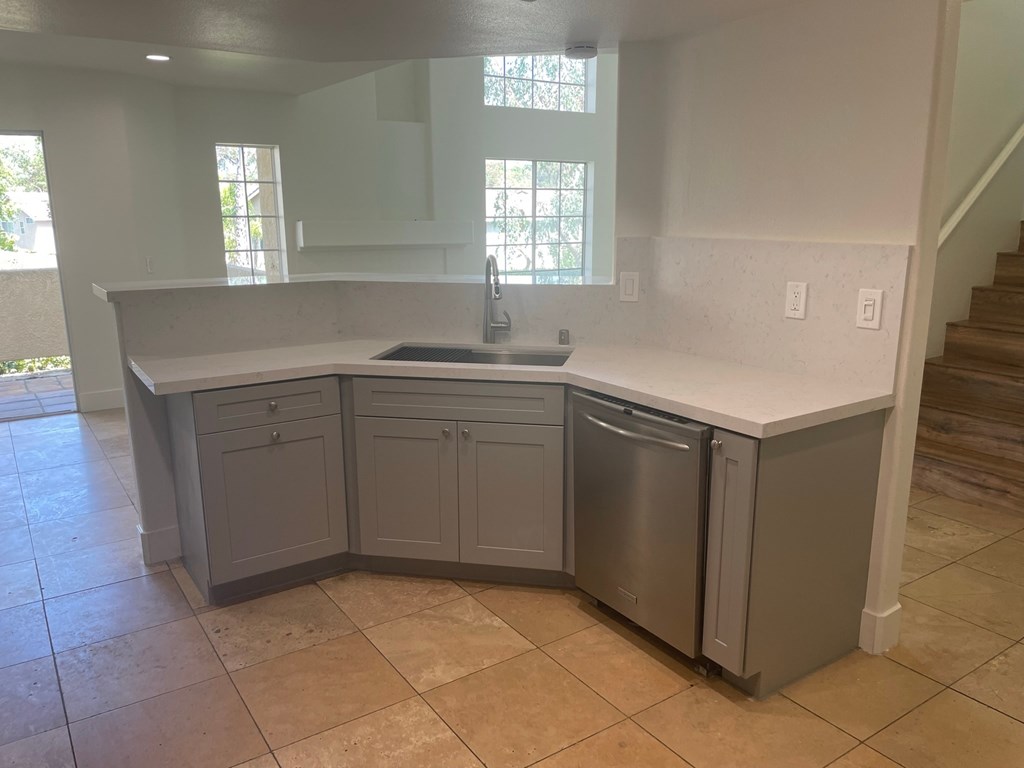 an empty kitchen with a sink and a counter
