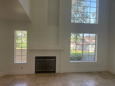 a living room with a fireplace and large windows