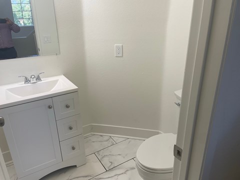 a bathroom with a sink toilet and a mirror
