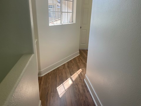 an empty room with hardwood flooring and a window